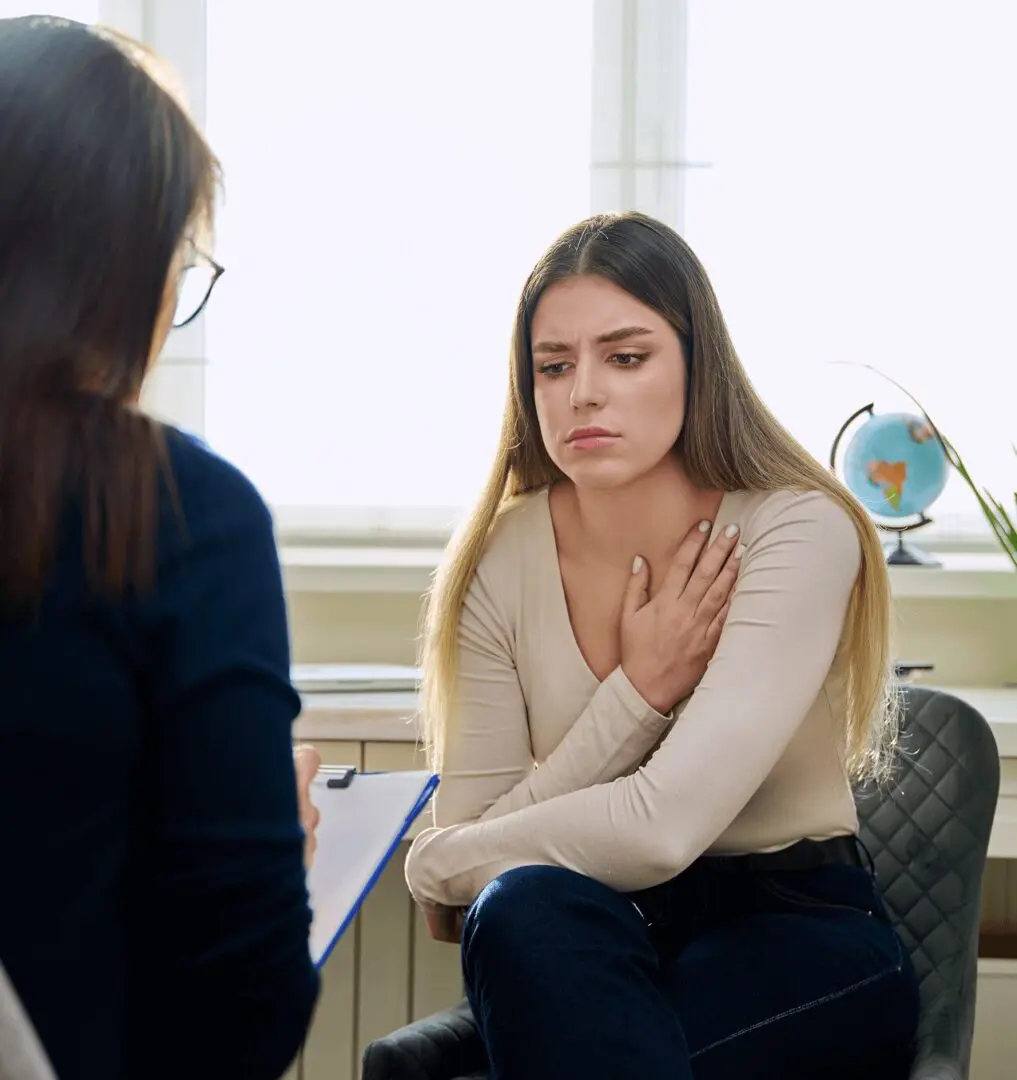 A woman sitting in front of another person.