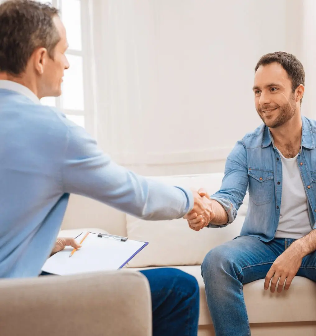 Two men are shaking hands in a room.