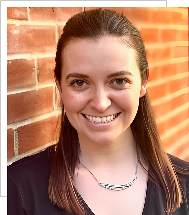 A woman standing in front of a brick wall.