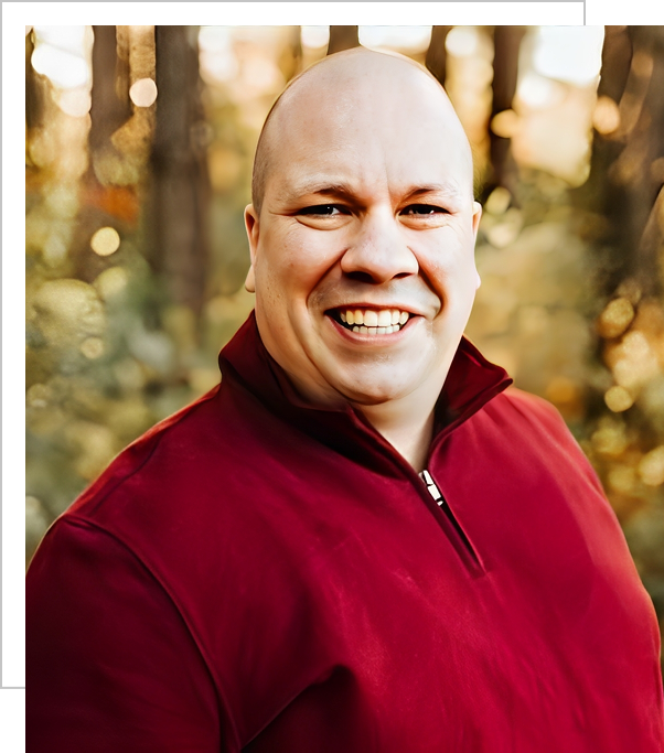 A man in red shirt smiling for the camera.